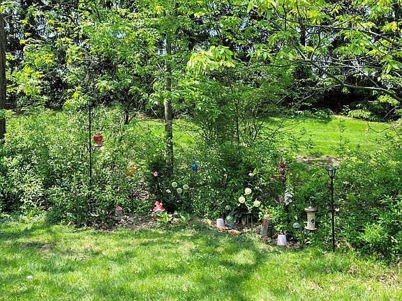 Decorative fairy garden with bird feeders and solar lights.