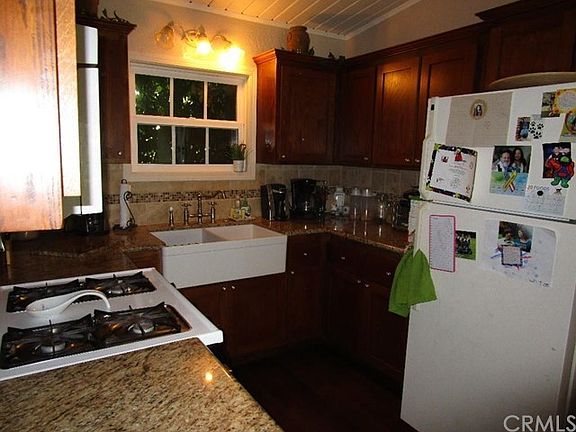 Beautifully updated kitchen with newer cabinets, granite counters, wood floor, country sink