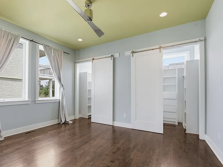 Master bedroom features lots of light, large windows, two separate walk in closets with barn doors