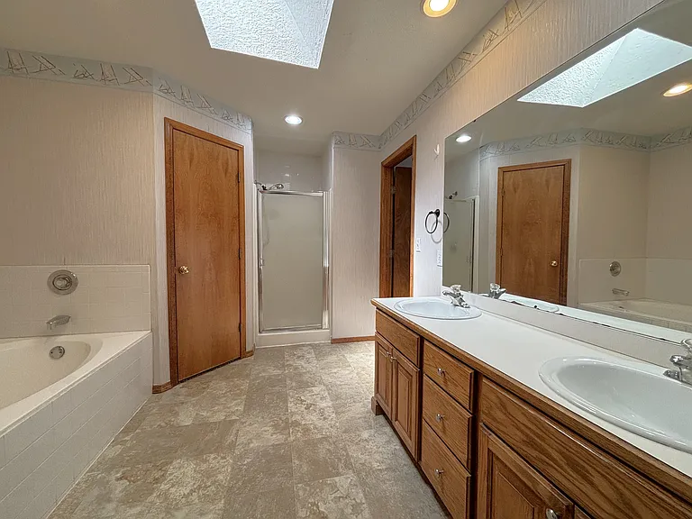 Primary Bathroom with Soaker Tub, Dual Closets, Skylight, and Shower