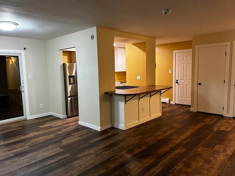 View of sliding door out to the deck and the kitchen island, the big pantry closet and the back door.