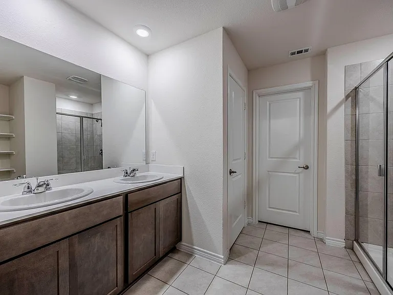 primary bathroom with dual sinks and large shower
