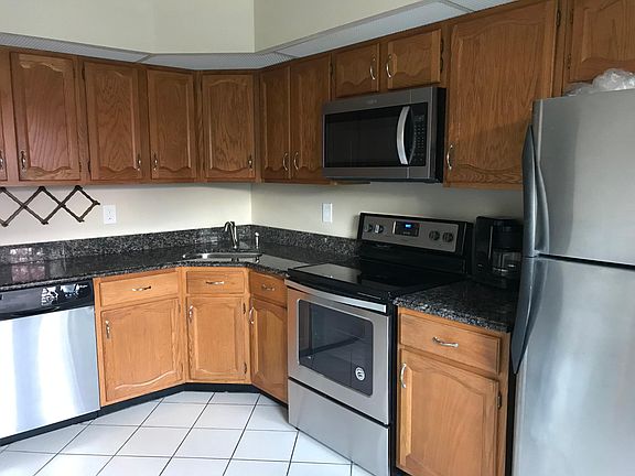 Stainless steel appliances and granite counter in a bright and sunny kitchen