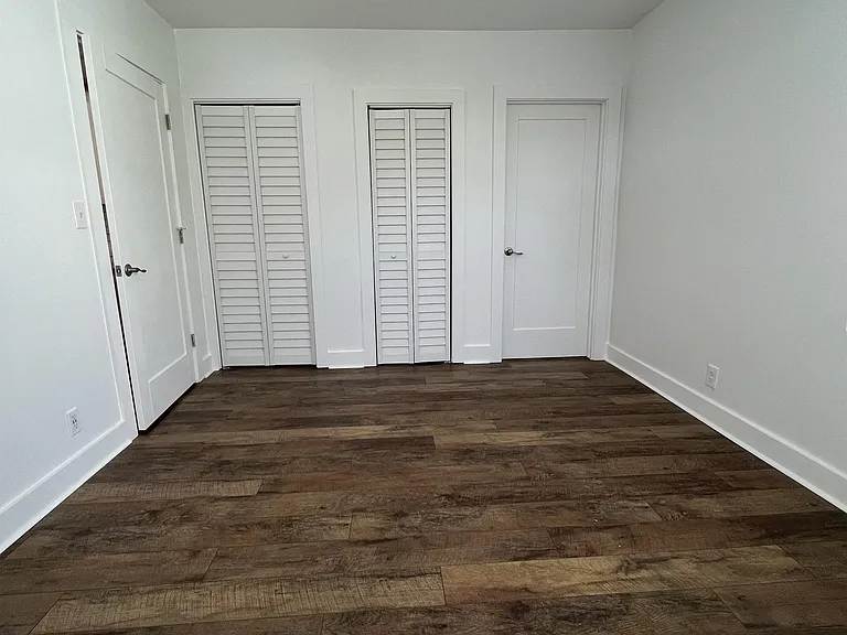 Bedroom, with the door to the living room/kitchen, the 2 closets, and the bathroom.