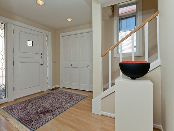 A spacious entry foyer features charming Dutch-door, beautiful millwork, large coat closet, oak hardwood floors & a gracious stairway that invites you up to the main living rooms.
