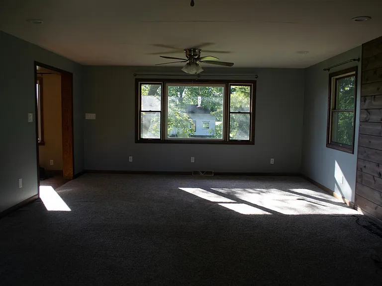 Living room with walk-out deck access and entertainment wall.