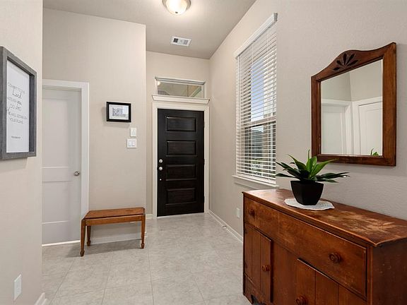 The open foyer and transom window offer natural light to flow into the entryway.