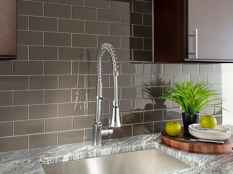 Kitchen with espresso cabinetry, granite countertop and tile backsplash