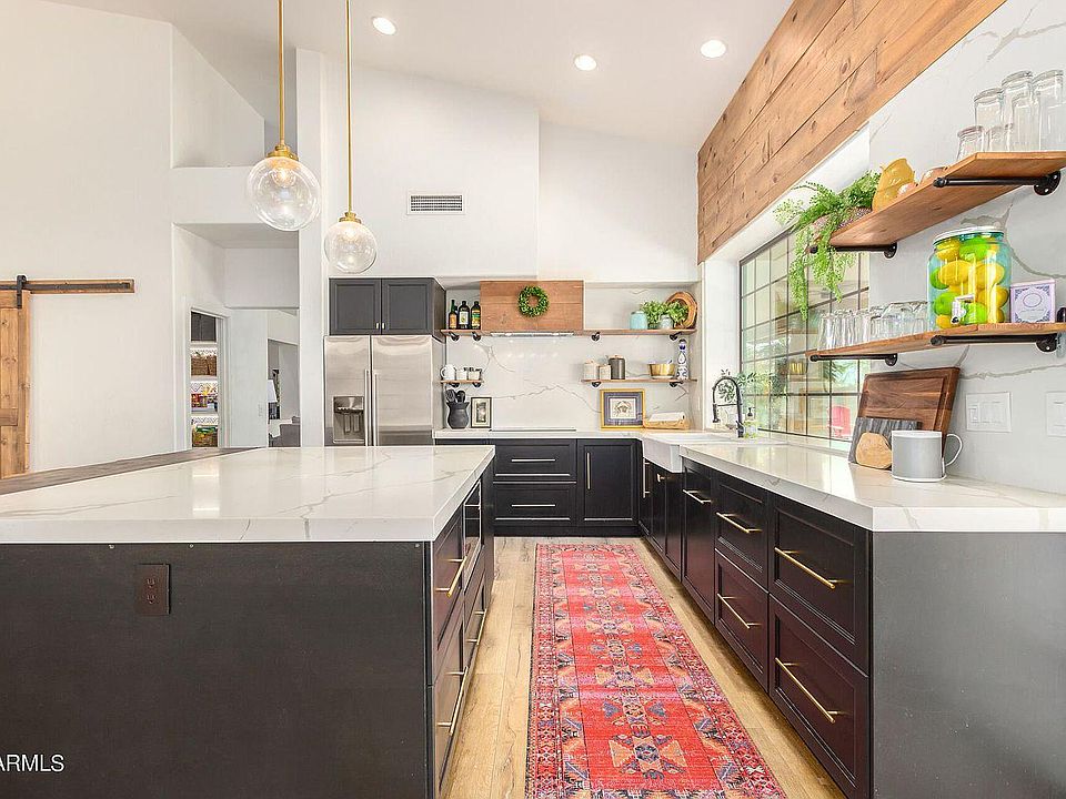 Kitchen has induction cooktop, massive island, quartz countertops and backsplash.