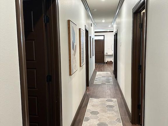 A view of the long hallway from the rear of the home looking towards the front door.