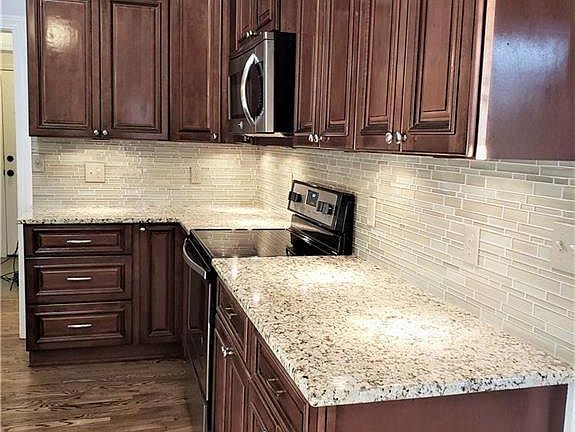 Granite counters, custom cabinets, granite counters, glass back splash, and a brand new stove make this the perfect kitchen.