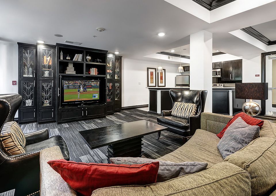 Clubroom with TV, lounge seating, and kitchen.