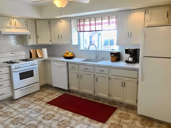 Kitchen with dishwasher and ducted range hood.