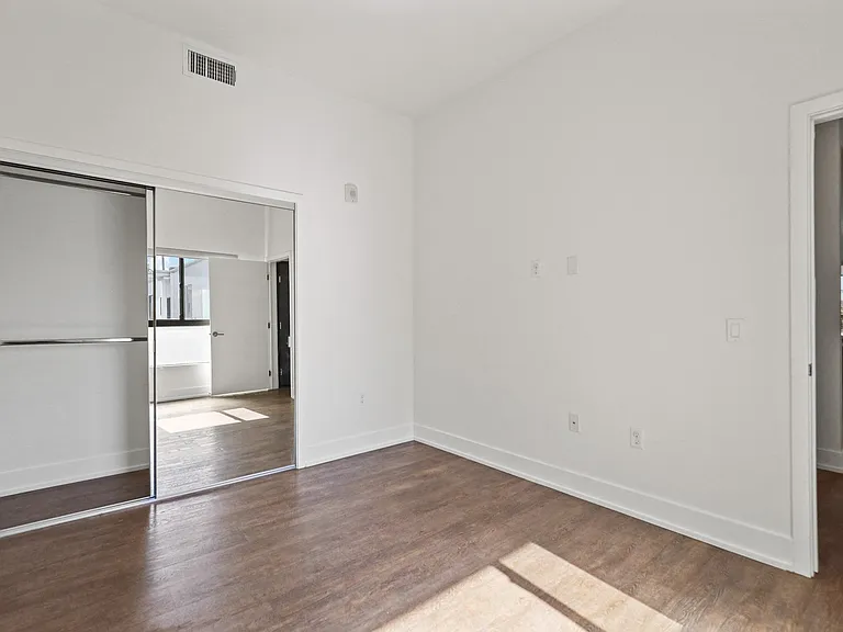 Bedroom with Mirrored Closet and Vinyl Flooring
