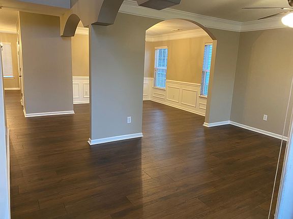 The open floor plan features continuous hardwood floors. Shown are the formal dining room & reception room.