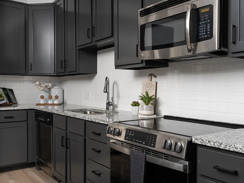Stainless steel appliances with modern white tile backsplash in kitchen