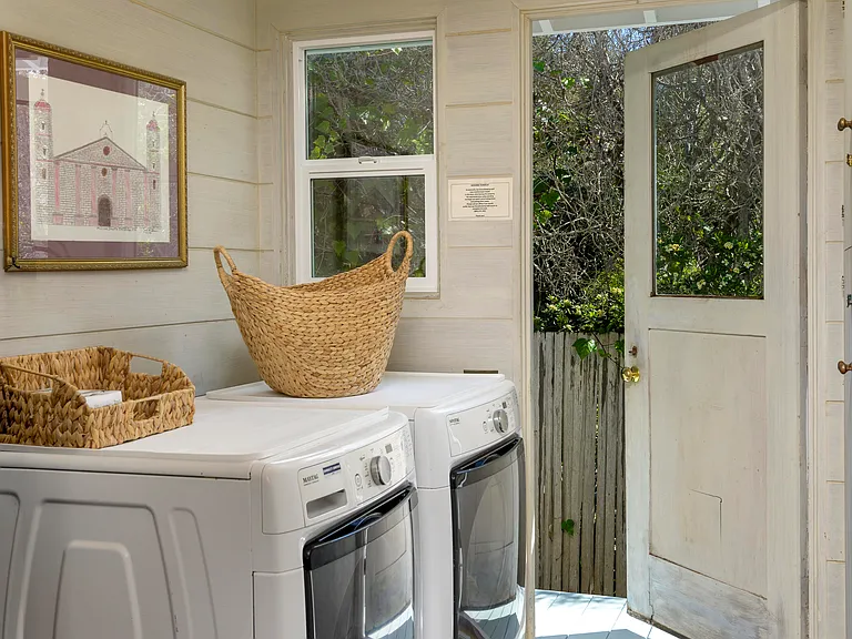 Laundry room with full size washer and dryer. Door out to side of house with outdoor shower steps away.