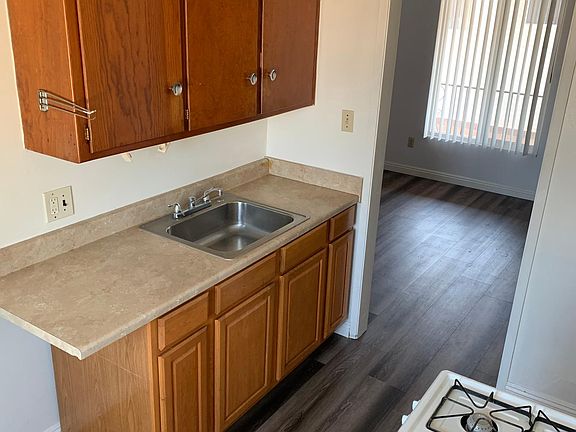 The kitchen showing the entrance, cabinets, sink, and gas stove.