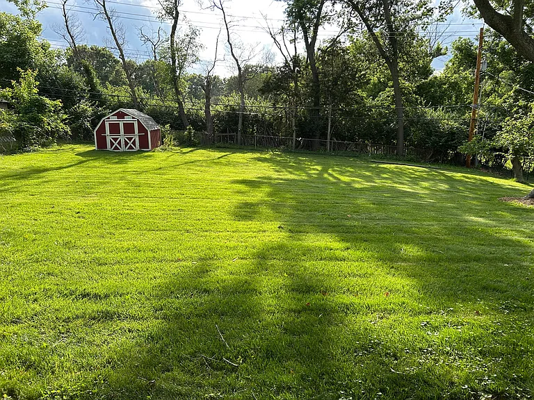 Here is one view of the large backyard, which is completely fenced in and offers lots of shade. You can enjoy this backyard without having to spend your time mowing it!