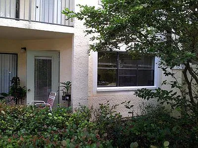 Side view of apartment, which has plenty of trees for shading and lower AC electric bills. (Off the side patio, there is an outside storage closet as well.)
