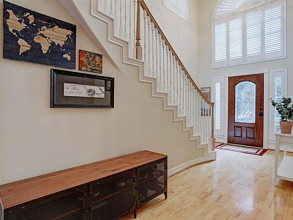 Large grand foyer with a gracious staircase, wood floors and plantation shutters throughout the home!