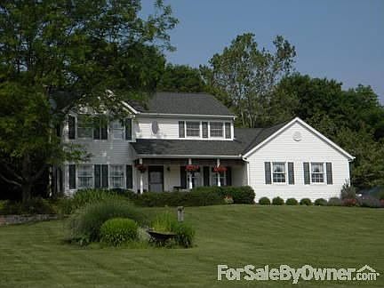 Front yard view of house and grass bed.