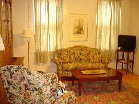 Spacious living room with sofa, easy chair, coffee table, TV