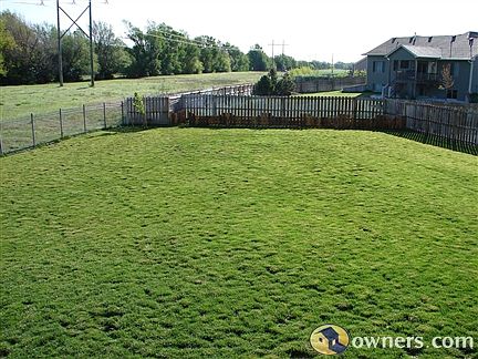 Back yard and garden fence. Sprinklers water lawn/garden