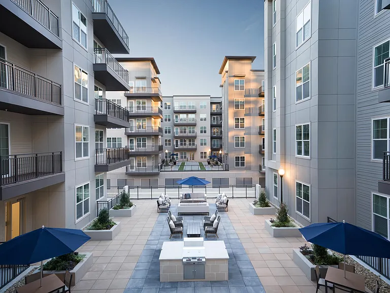 Visit the inviting courtyard with lounge seating, grilling stations, and open-air gathering space at Modera Liberty Row.