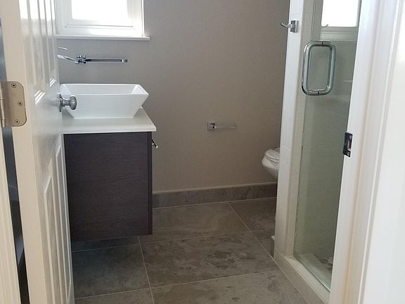 Bathroom with shower, sink, window, toilet