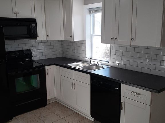 Kitchen with dishwasher, range, microwave and fridge.