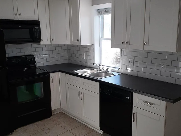 Kitchen with dishwasher, range, microwave and fridge.