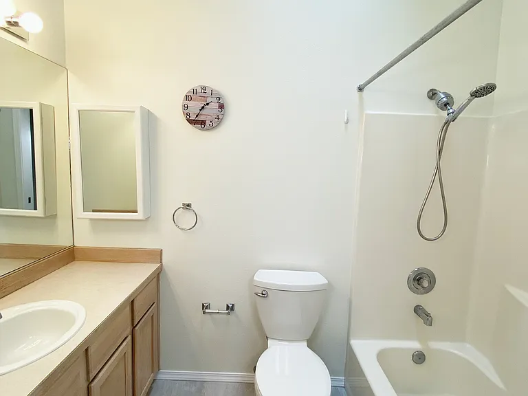 Third-level bathroom with soaking tub, shower and bright vanity area.