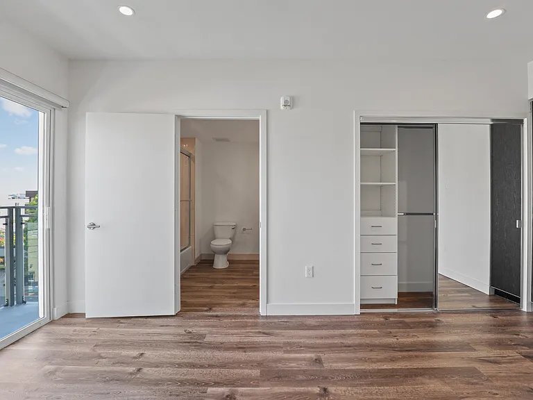 Large-Size Bedroom with Vinyl Flooring, Mirrored Closet, and Patio