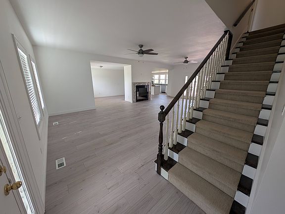 View from the front door. Stairs, Living Room, Fireplace, Kitchen in the background.