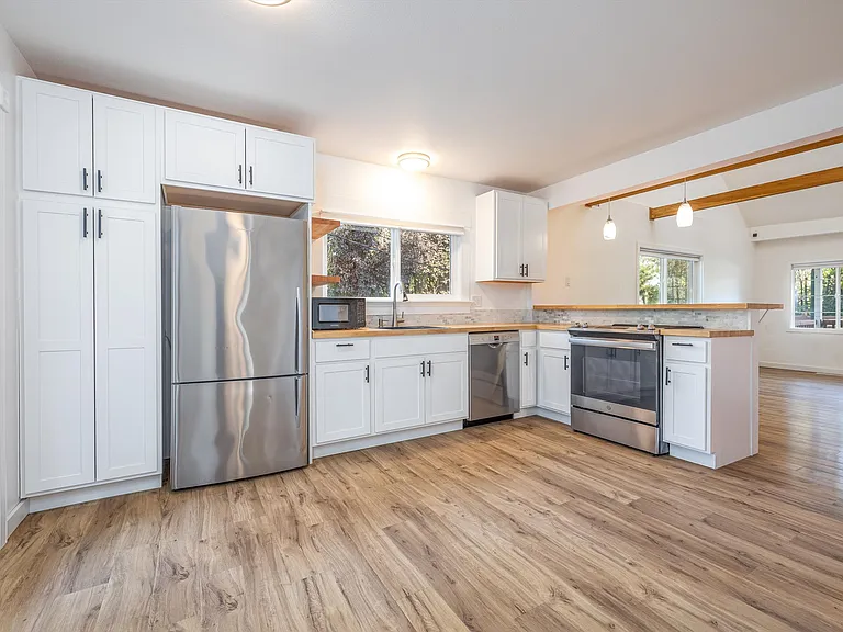 Open concept kitchen with ample storage space and French doors that lead to deck.