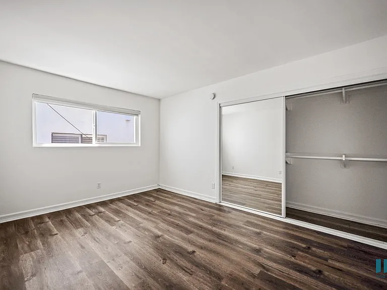 Bedroom with Large-Size Mirrored Closet and Vinyl Flooring