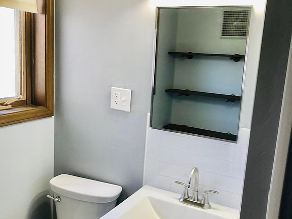 Full bath with shower and updated 
 tile. Cabinet above sink, I removed mirror to clean, has mirror that I put back on. Its' not just shelves. Updated cabinet.