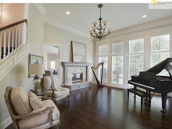 Grand living room w/ hardwood floors, plantation shutters and fireplace.