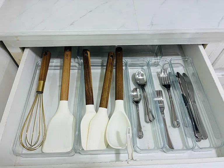 Kitchen drawer storage includes built-in organizers with dedicated spaces for utensils and cooking tools.