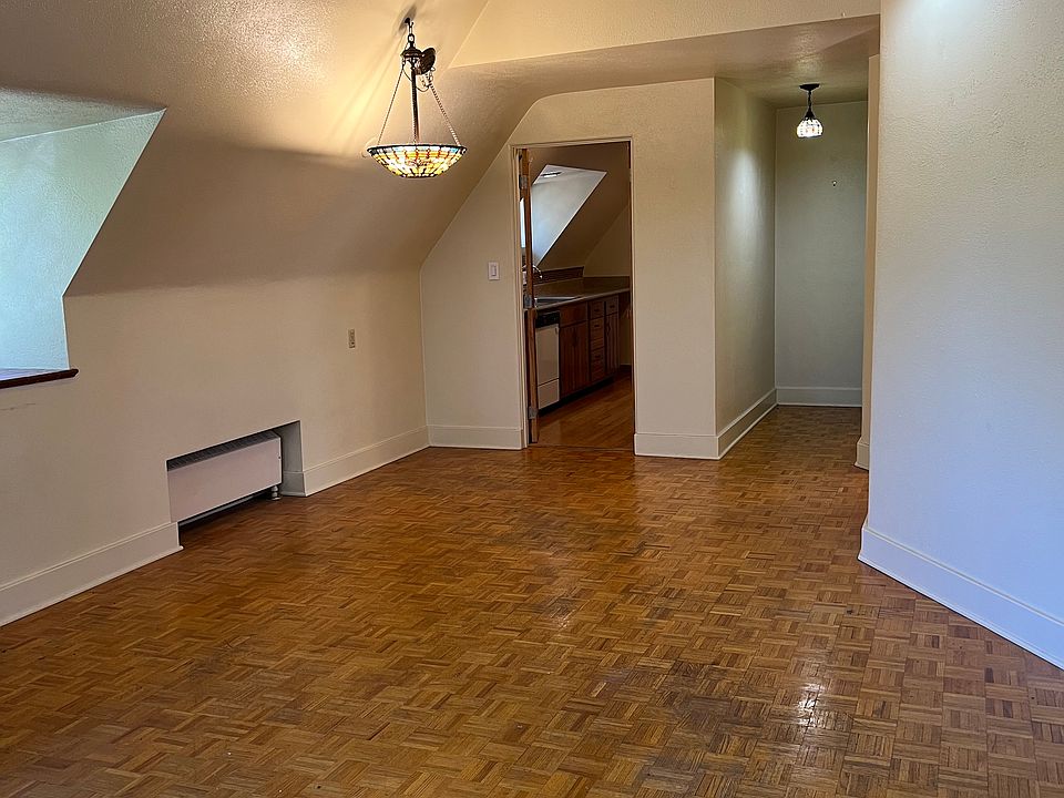 Spacious living area with real wood parquet flooring throughout, cottage windows with deep window sills, with excellent natural lighting, and decorative stained glass light fixtures.