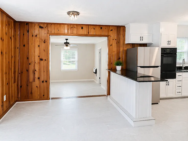 Open dining room area that leads to stepdown TV room or den area. New vinyl tile in dining, kitchen and TV areas.