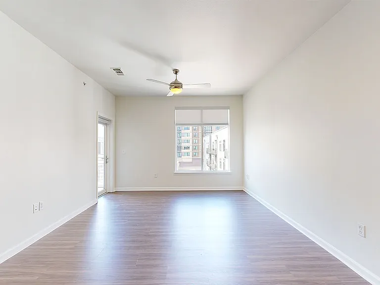 Apartment dining and living room with wood-style flooring.