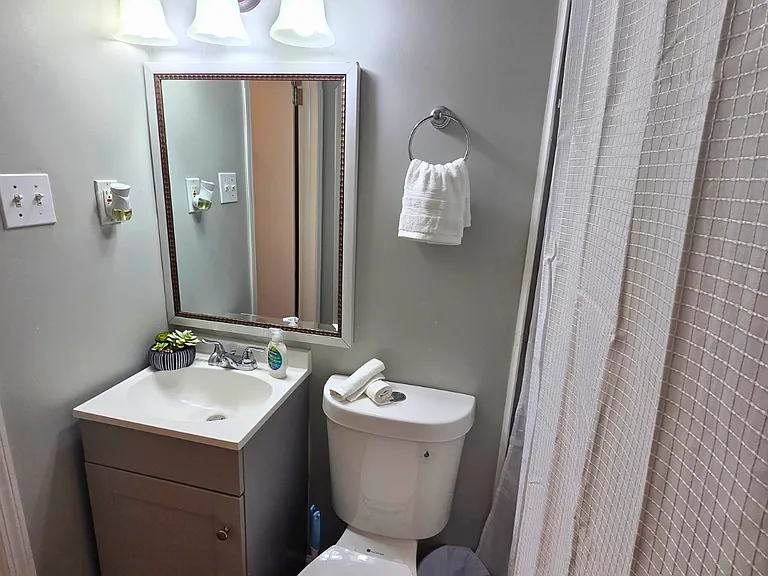 Bathroom equipped with towels, cabinet, and towel holders.