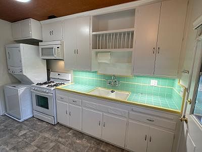 Kitchen with washer/ dryer.