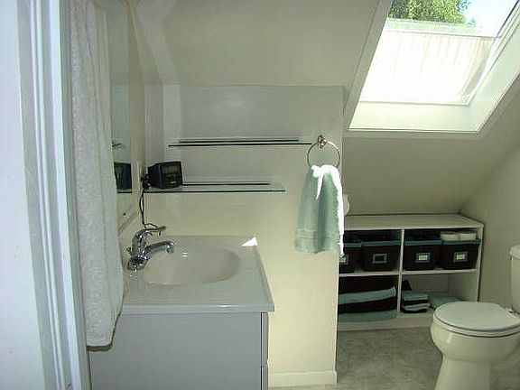 Master suit bathroom with skylight, custom storage and corner shower