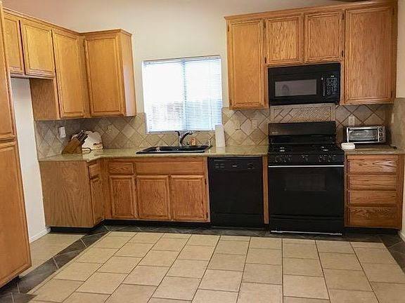 Kitchen has granite counters, tile backsplash and floor