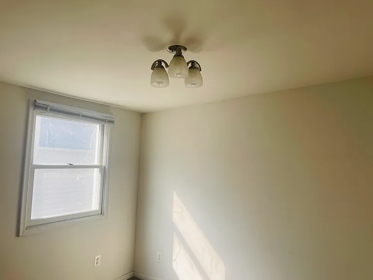 Corner and window in the middle bedroom. Window looks out at the house next door/side yard