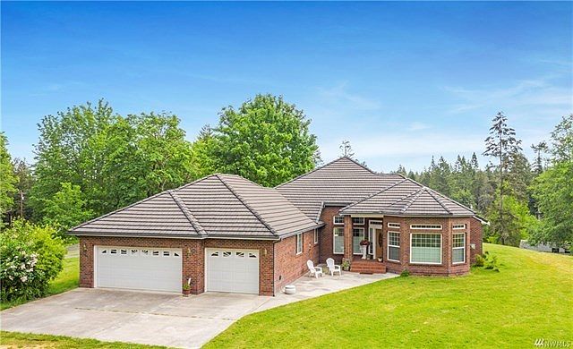 Custom home on sitting high on a knoll with extensive brickwork and tile roof.  Beautiful territorial views and lots of room for pets and play.  Oversized 3 car garage and heat pump.