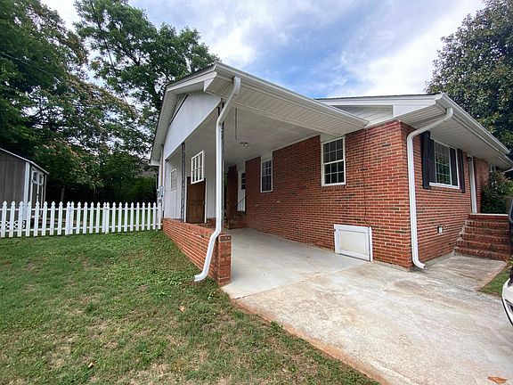 Carport with side door entrance and attached storage shed.